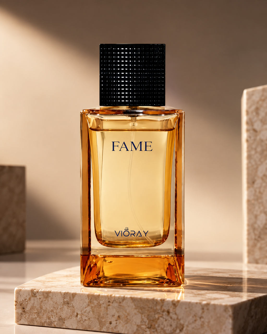 A rectangular glass fragrance bottle labeled FAME by VIORAY, filled with amber liquid and topped with a black textured cap, displayed on a stone pedestal in warm studio lighting.